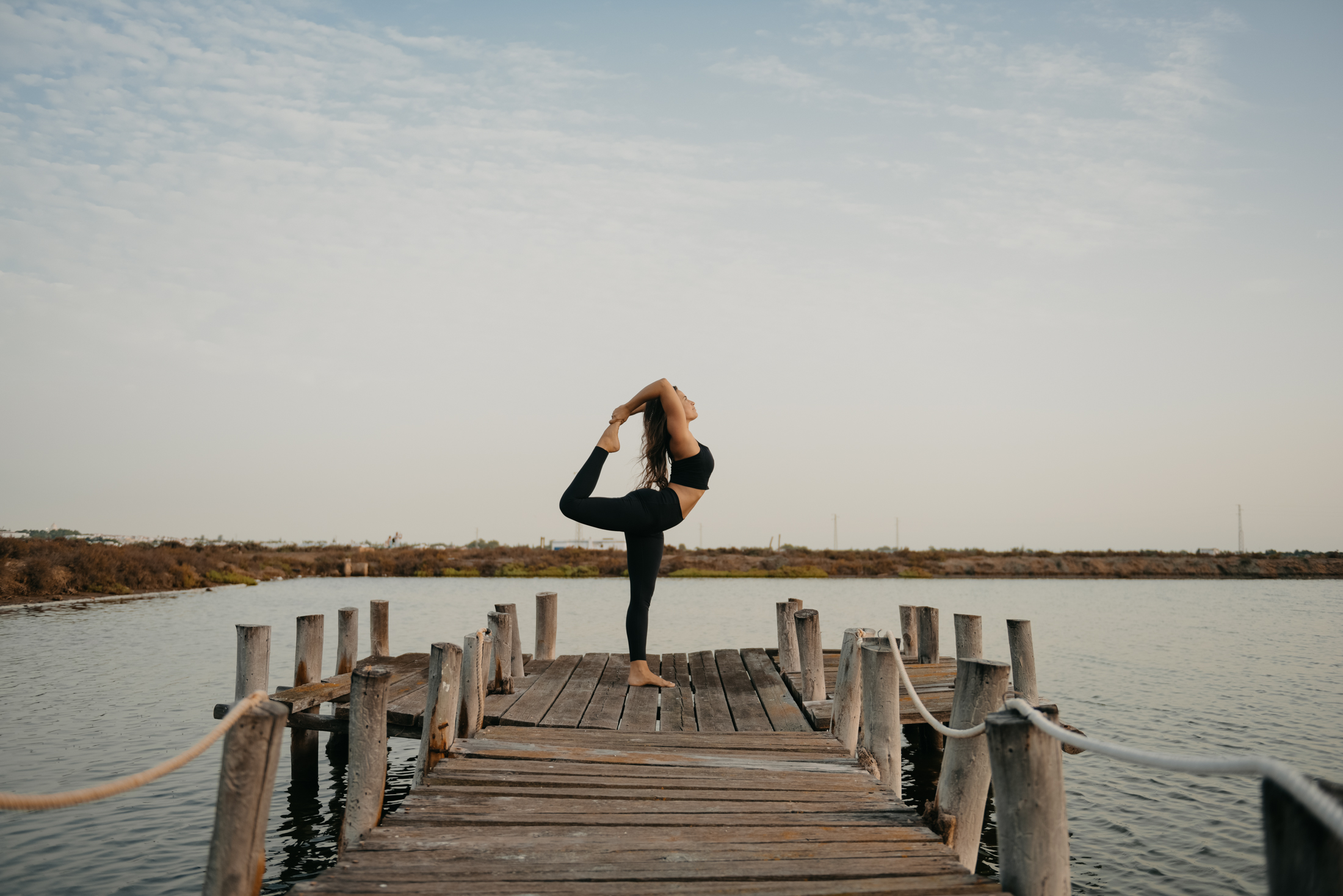 Cris practicando yoga al atardecer en la salina de Chiclana